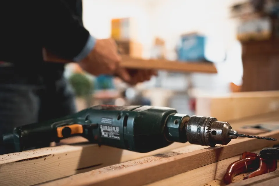 Handyman drilling into a wood board