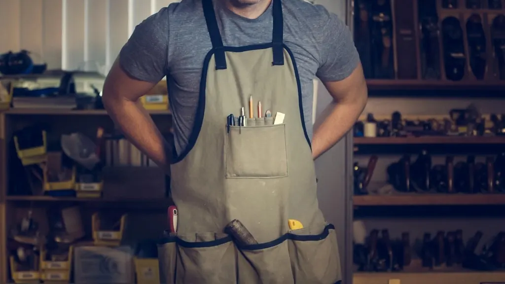 Handyman wearing a tool apron in a workshop