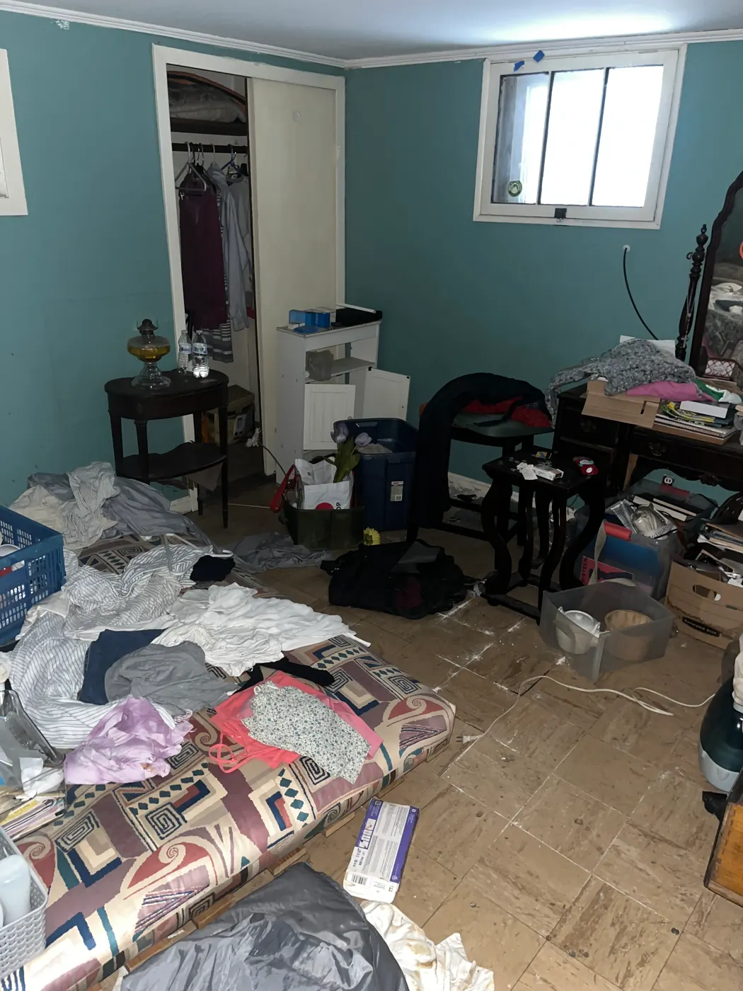 Bedroom piled with clothes and bags before a Mint Soup cleanout