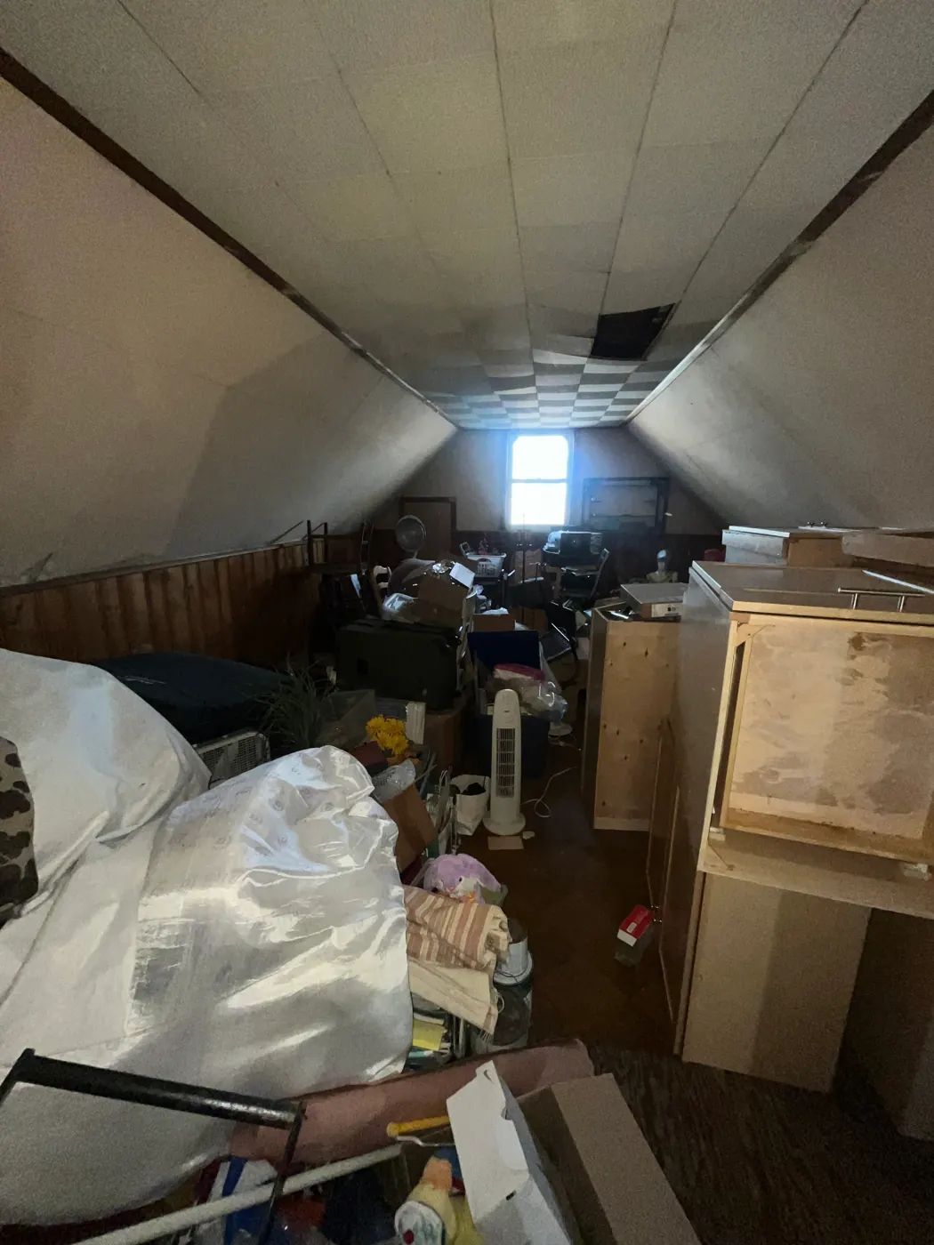 Attic crawl space packed with bags and furniture