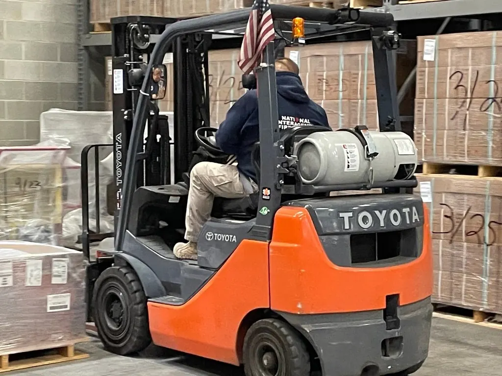 Forklift moving stacked boxes in a warehouse