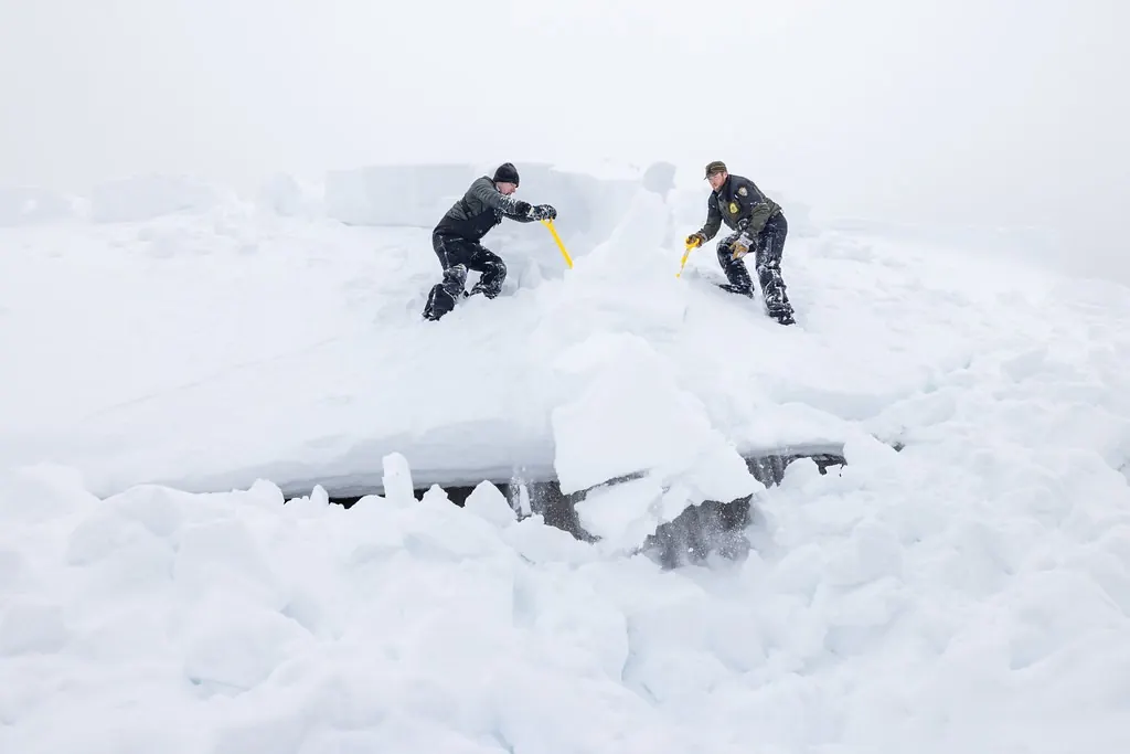 Two people shoveling out deep snow