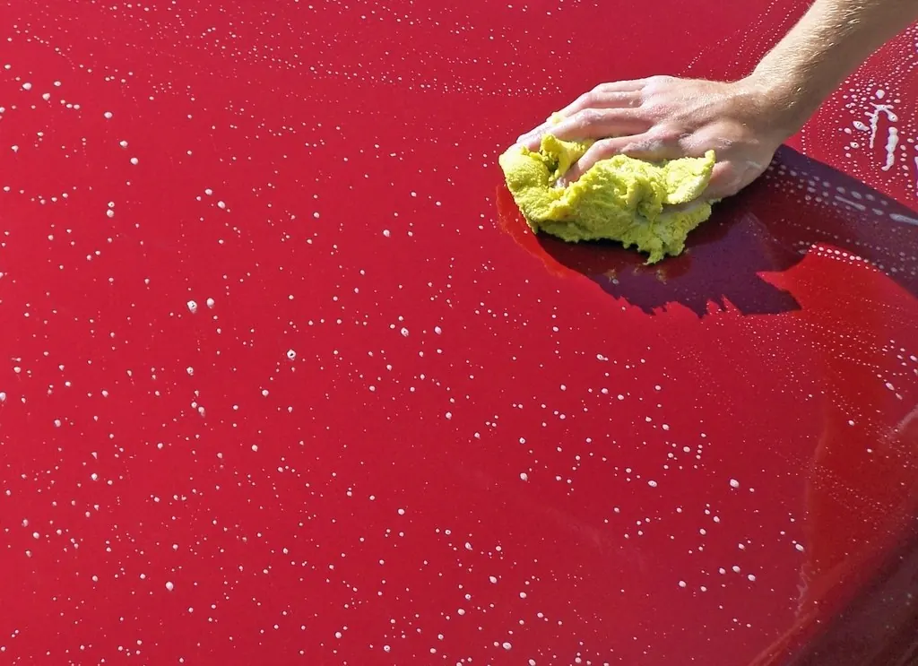 Exterior wash: Washing red car sponge close