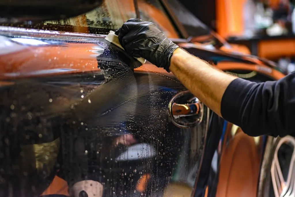 Detailer cleaning a car door panel